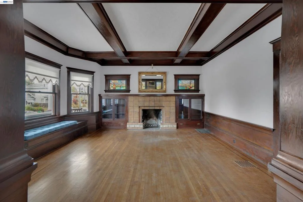 Unfurnished living room with front windows and stone fireplace