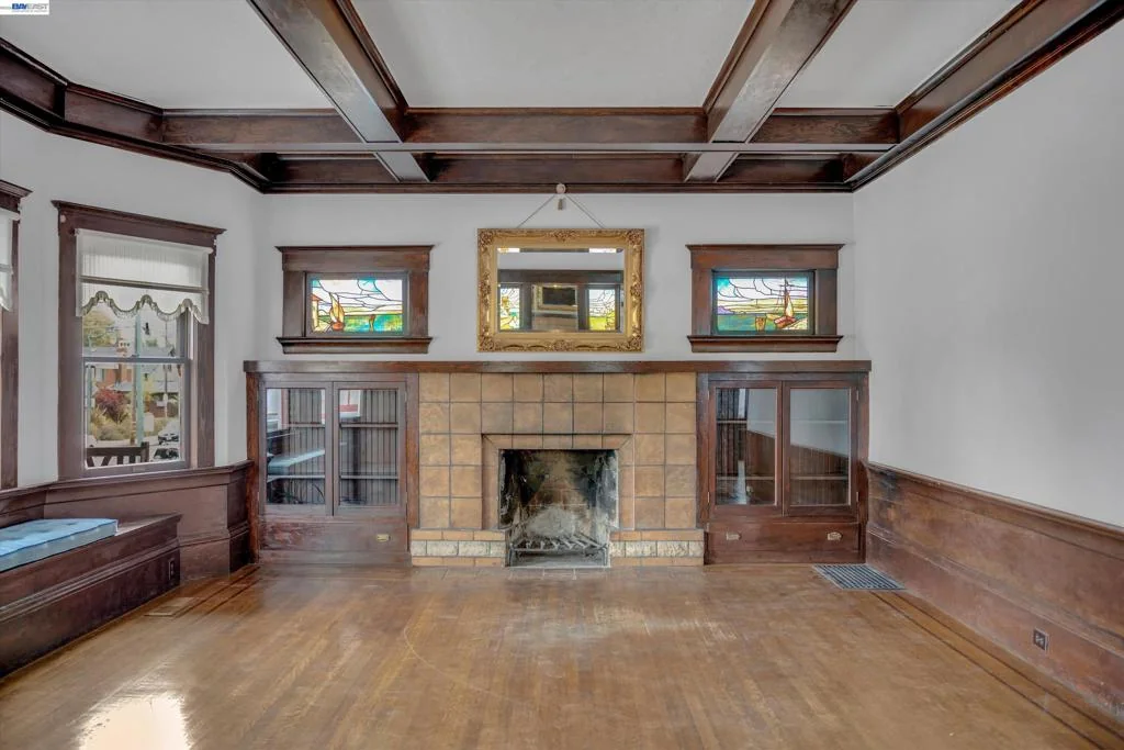 Stone fireplace beneath the living room's coffered ceiling