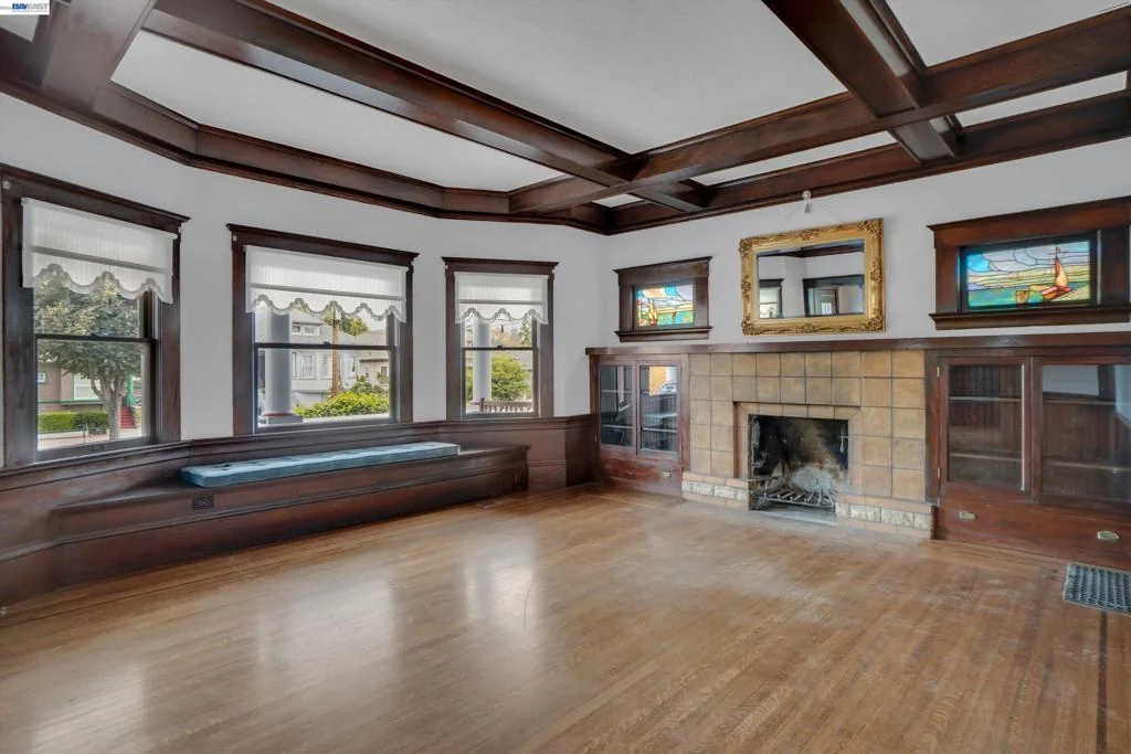 Open living room with wraparound windows and original wood trim