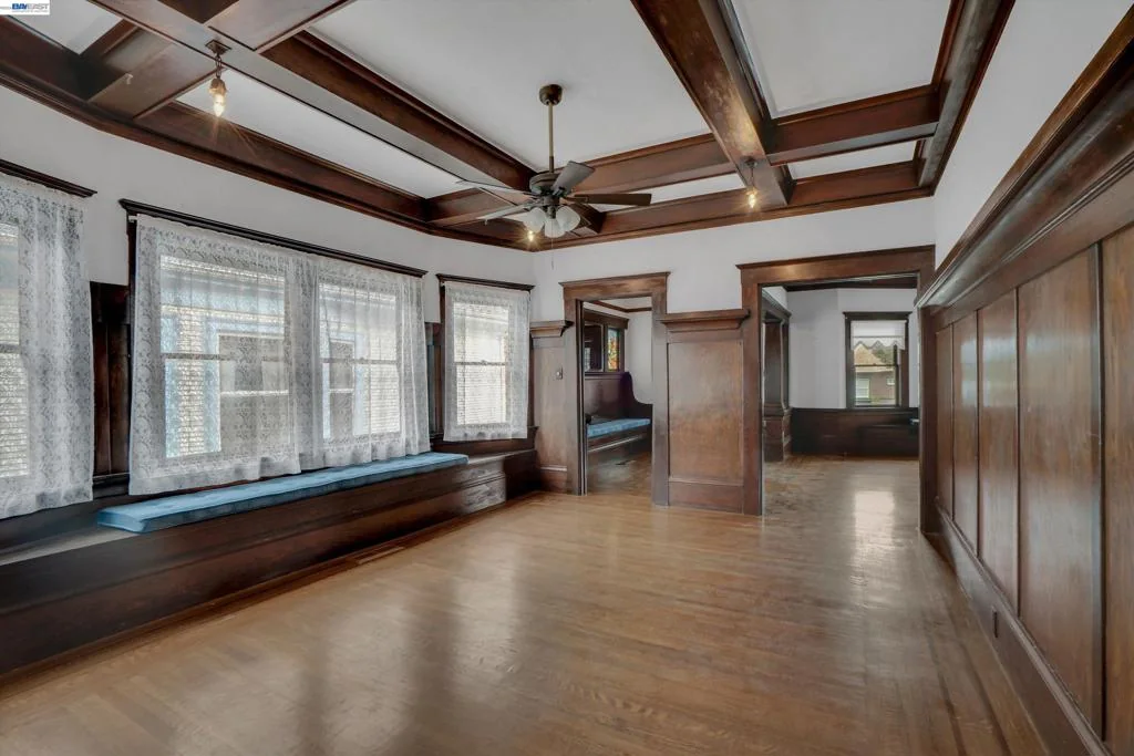 Unfurnished formal dining room with coffered ceiling and wide windows