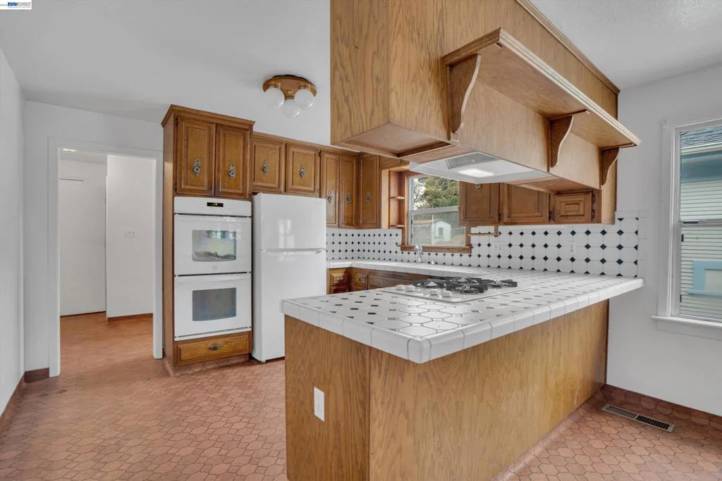 Kitchen with wood cabinets, white appliances, and checkerboard flooring